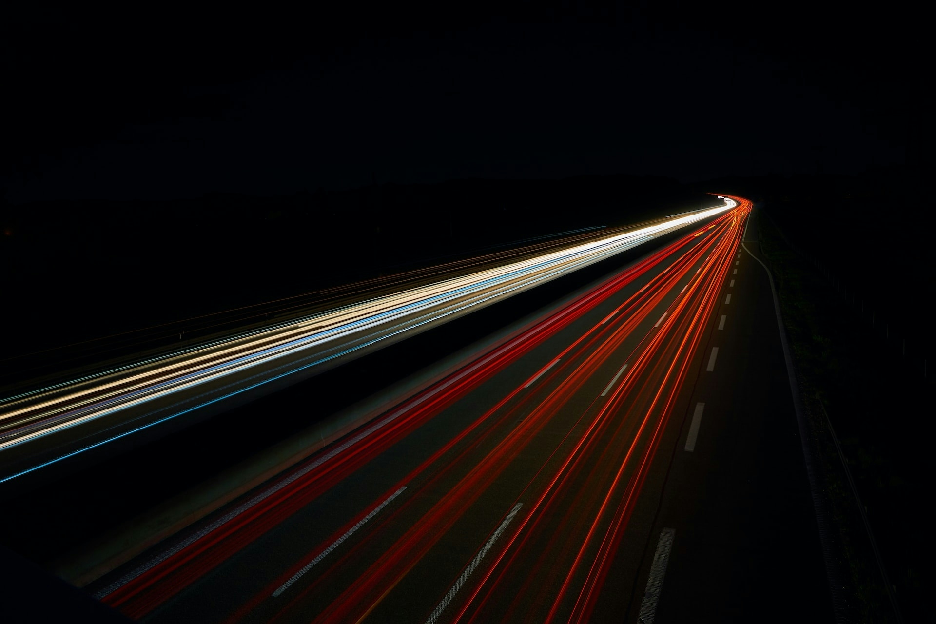 Slow shutter photograph of cars driving on a highway.